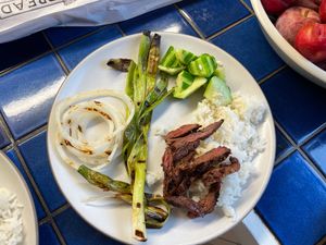 Bulgogi on rice with onions and cucumber, served on a plate