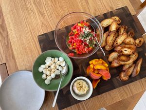Serving display of bruschetta, crostini, mozzarella, and roasted garlic