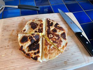 Quesadillas arranged like a pizza on a cutting board