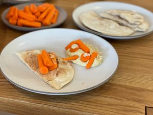 Carrots arranged into a face on top of some hummus