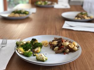 Pulled pork with pasta and broccoli on plates