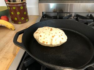 a tortilla puffed up in a cast iron skillet