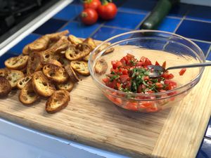 bruschetta in a bowl next to crostini