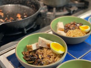 Turkey ramen in front of a pan of sauteed mushrooms