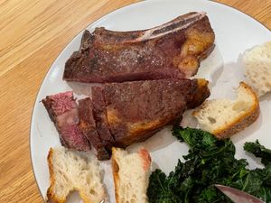Ribeye on a plate with bread and kale