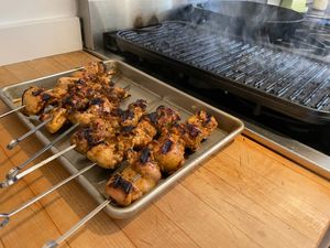 Chicken resting in front of a hot grill pan